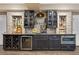 Well-appointed bar area with wine storage, mini-fridge, glass shelving, and stylish countertops at 15720 Columbus Mountain Dr, Broomfield, CO 80023