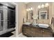 Elegant bathroom featuring double sinks, granite countertops, modern fixtures, and a glass-enclosed shower at 15720 Columbus Mountain Dr, Broomfield, CO 80023