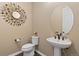 Stylish powder room with pedestal sink, hardwood floors, and a decorative mirror at 15720 Columbus Mountain Dr, Broomfield, CO 80023