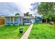 Inviting backyard featuring a blue house with a sunroom, a wooden deck, and a well-manicured lawn at 1720 Trenton St, Denver, CO 80220