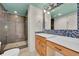 Bathroom with stand up shower, mosaic tile, and vanity with wood drawers at 1720 Trenton St, Denver, CO 80220
