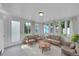 Bright sun room with walls of windows and furniture, overlooking the backyard at 1720 Trenton St, Denver, CO 80220