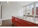 Modern kitchen with marble island and stylish red cabinetry with great natural light from the large windows at 720 16Th St # 306, Denver, CO 80202