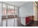 Open-concept living room with hardwood floors, city views, and modern kitchen island with red cabinetry at 720 16Th St # 306, Denver, CO 80202