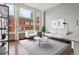 Bright living room boasts large windows with city views, light gray sofa set, and stylish decor at 720 16Th St # 306, Denver, CO 80202