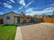 Backyard featuring a covered patio area with grill, a rock area, and a well-maintained green lawn at 2235 W 46Th Ave, Denver, CO 80211