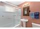 Cozy bathroom with shower-tub combo, pedestal sink, and rustic mirror at 2235 W 46Th Ave, Denver, CO 80211