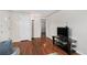 Cozy living room with hardwood floors, a modern TV setup, and a view into the hallway at 2235 W 46Th Ave, Denver, CO 80211
