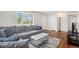 Comfortable living room featuring a plush gray sectional sofa, hardwood floors, and natural light at 2235 W 46Th Ave, Denver, CO 80211