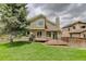Well-maintained, green backyard with a wooden deck and mature tree, perfect for outdoor enjoyment at 8652 Aberdeen Cir, Highlands Ranch, CO 80130