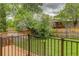 Backyard view features a well-maintained lawn, wood fence, and iron railings offering privacy and security at 8652 Aberdeen Cir, Highlands Ranch, CO 80130