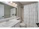 Bathroom featuring a white vanity, mirror, and a shower-tub combination with a decorative curtain at 8652 Aberdeen Cir, Highlands Ranch, CO 80130