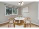 Simple dining area with a round table, four chairs, hardwood floors and a large window at 8652 Aberdeen Cir, Highlands Ranch, CO 80130
