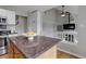 Open-concept kitchen featuring an island with stone countertops and modern appliances that flows into the living space at 8652 Aberdeen Cir, Highlands Ranch, CO 80130