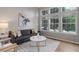 Sunlit living room with large windows, grey sofa, white chairs and stylish decor at 8652 Aberdeen Cir, Highlands Ranch, CO 80130