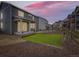 Backyard with artificial turf and bark landscaping at dusk, creating a cozy ambiance at 1373 E Witherspoon Dr, Elizabeth, CO 80107