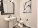 Powder room featuring modern fixtures, a pedestal sink, a sleek mirror, and neutral decor at 1373 E Witherspoon Dr, Elizabeth, CO 80107