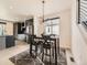 Stylish dining area with a modern chandelier, dark wood table, black chairs, and view to the kitchen at 1373 E Witherspoon Dr, Elizabeth, CO 80107