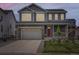 Charming two-story home featuring a gray exterior, stone accents, a two-car garage, and a cozy front porch at 1373 E Witherspoon Dr, Elizabeth, CO 80107