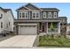 Charming two-story home featuring a gray exterior, stone accents, a two-car garage, and a cozy front porch at 1373 E Witherspoon Dr, Elizabeth, CO 80107