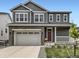 Charming two-story home featuring a gray exterior, stone accents, a two-car garage, and a cozy front porch at 1373 E Witherspoon Dr, Elizabeth, CO 80107