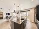 Open-concept kitchen with a center island, sleek black cabinetry, tile flooring, and view to the living room at 1373 E Witherspoon Dr, Elizabeth, CO 80107