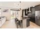 Bright, modern kitchen with a center island, sleek black cabinetry, stainless steel appliances, and a sliding door to the backyard at 1373 E Witherspoon Dr, Elizabeth, CO 80107