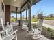 View of a community clubhouse porch with white rocking chairs and manicured landscaping at 1373 E Witherspoon Dr, Elizabeth, CO 80107