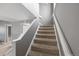 Carpeted stairway with white railing and gray walls connecting the levels of this home at 11103 E Alameda Ave # 201, Aurora, CO 80012