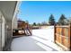 Snowy backyard view with wooden fence, deck and stairs, next to the house at 4419 S Xenophon Street, Morrison, CO 80465