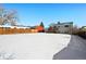 Spacious, snow-covered backyard with a view of the house and surrounding neighborhood at 4419 S Xenophon Street, Morrison, CO 80465