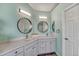 Bright bathroom features dual sinks, modern countertops, round mirrors, and updated lighting fixtures at 600 Coyote Trl, Elizabeth, CO 80107