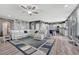 Open living room with fireplace, ceiling fan, grey accent wall, and a large sectional couch at 600 Coyote Trl, Elizabeth, CO 80107