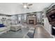 Living room with stone fireplace, ceiling fan, and a view into kitchen and back yard at 600 Coyote Trl, Elizabeth, CO 80107