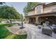 Back patio features stone pillars, outdoor kitchen, with view of the pool and landscaped yard at 6783 E Orchard Rd, Greenwood Village, CO 80111