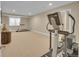 Finished basement with exercise equipment, carpeted floors and a bright window at 6783 E Orchard Rd, Greenwood Village, CO 80111
