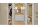 Elegant bathroom featuring tiled walls, modern vanity, and walk-in closet access at 6783 E Orchard Rd, Greenwood Village, CO 80111