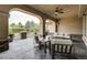 Covered patio with stone pillars has an outdoor living area with comfortable seating and ceiling fan at 6783 E Orchard Rd, Greenwood Village, CO 80111