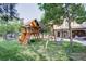 A wooden playset with swings, slide and lookout, plus a trampoline, near home's patio at 6783 E Orchard Rd, Greenwood Village, CO 80111