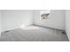 A bright bedroom with light gray carpet and white walls is illuminated by a large window at 1242 Penner Dr, Erie, CO 80026