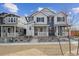 Charming townhome featuring a covered front porch and contemporary gray and white exterior at 1242 Penner Dr, Erie, CO 80026