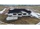 New home featuring white exterior, black trim, and concrete patio in a snowy landscape at 5424 Freddys Trl, Parker, CO 80134