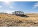 A single-story white home with a walkout basement on a large lot with prairie grass at 5424 Freddys Trl, Parker, CO 80134