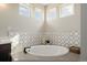 Bright bathroom featuring an oval soaking tub and a decorative tile backsplash at 5424 Freddys Trl, Parker, CO 80134