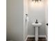 Bathroom showcases pedestal sink, dark wood floors, and classic towel rack at 5424 Freddys Trl, Parker, CO 80134