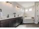 Bright bathroom featuring dual sinks, tile backsplash, and a soaking tub at 5424 Freddys Trl, Parker, CO 80134