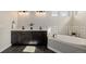 Bathroom showcasing dual sinks, dark cabinets, a soaking tub with decorative tile backsplash, and modern fixtures at 5424 Freddys Trl, Parker, CO 80134