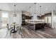 Spacious kitchen features seating at island, stainless appliances, and flows into an adjacent dining area at 5424 Freddys Trl, Parker, CO 80134