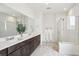 Bright bathroom with double sink vanity, large mirror and a glass-enclosed shower with white tile surround at 6263 E 142Nd Pl, Thornton, CO 80602