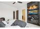 Modern bedroom with television mounted on black marble and a glimpse into the attached bathroom at 6263 E 142Nd Pl, Thornton, CO 80602